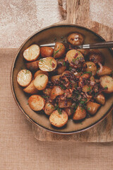 Savory roasted potatoes topped with herbs and caramelized onions in a rustic setting
