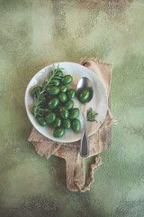 Chalkidiki olives, classic Greek green olive, on a plate, with a spoon, top view, no people,