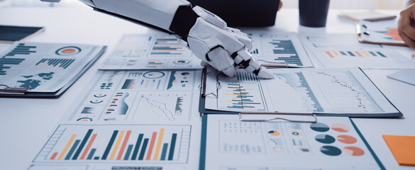 A robotic arm interacts with various business reports and graphs on a desk, highlighting the...