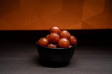 A bowl full of gulab jamun in sugar syrup pool, luxury dessert