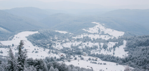 Panoramic view of a snowy mountain village in a valley