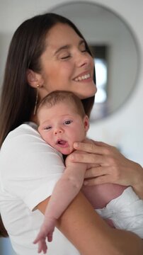 ender mother gently holding newborn baby girl resting peacefully on her chest in bedroom