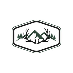 A minimalist outdoor adventure logo featuring deer antlers framing a mountain range and pine trees within a hexagonal badge.