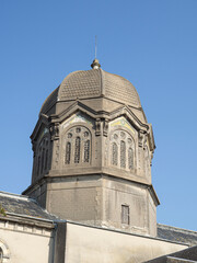 Vista de la torre con forma de cilindro sobre fondo azul del cielo de la Iglesia de Saint-Paul de Granville, Cotentin, en Normand&iacute;a, viajando por Francia en verano de 2022.