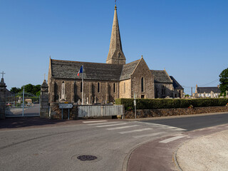 Iglesia Saint-Pair de Saint-Pair-sur-Mer en Normandía Francia, construcción en piedra típica normanda su torre campanario alta y puntiaguda