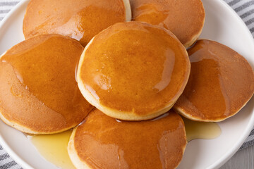 Fluffy pancakes drizzled with honey on a white plate during breakfast