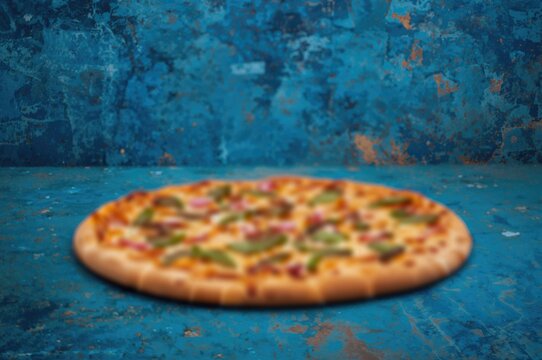 Out-of-focus pizza set against a textured blue background