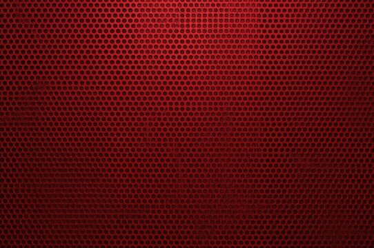 Curved crimson metal lattice featuring perforations in the background