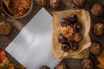 Grilled chestnuts presented on rustic brown and white paper with room for writing