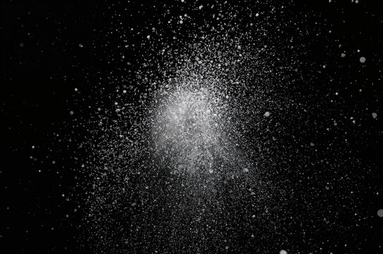 White particles bursting against a dark background
