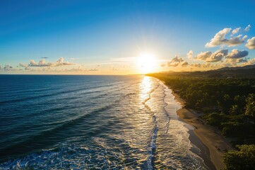 Obraz premium A stunning dawn breaks over a peaceful sea and verdant forest