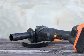 Angle grinder with battery. Power tool close-up. Angle grinder on the veranda. Repair and construction tool. Angle grinder with handle