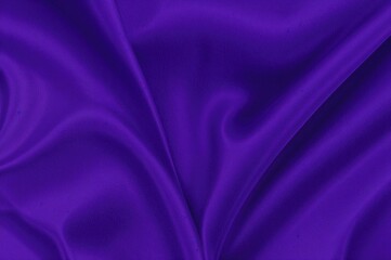 Dark blue and purple silk satin backdrop with gentle waves and glossy texture. Ample space for text or items. Elegant deep violet setting. Online banner design.