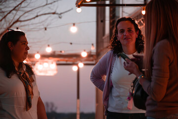 Reunión de mujeres al atardecer con luces colgantes en el Lago Piedras Moras, Almafuerte, Córdoba