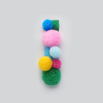Colorful letter I made of fluffy pom poms on white background. Creative handmade typography for kids learning alphabet, educational design, playful classroom decor, and graphic projects.