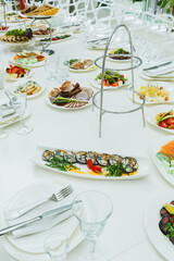 Diverse dishes spread across a dining table set for a festive gathering with elegant decor and vibrant food selections during a sunny afternoon