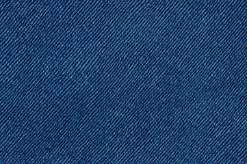 Detailed close-up of blue denim fabric revealing its complex texture and diagonal weave