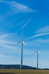 Fototapeta premium Dancing turbines on a clear day under bright blue skies with gentle winds in a serene countryside setting showcasing renewable energy sources