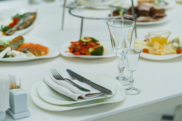 Elegant dining setup with assorted dishes, cutlery, and beverages at a lavish gathering