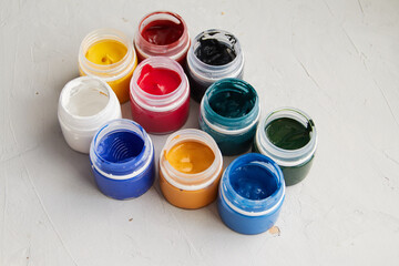 colorful acrylic paint in jar, grey dirty background,  artists materials photography
