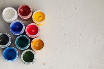 colorful acrylic paint in jar, grey dirty background,  artists materials photography