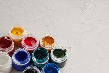 colorful acrylic paint in jar, grey dirty background,  artists materials photography