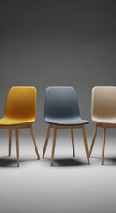 Obraz premium Three modern upholstered chairs in yellow, blue, and beige sit elegantly against a neutral gray backdrop, showcasing contemporary design and comfort.