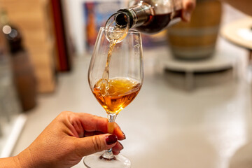 Tasting of Banyuls AOC aged natural sweet grand cru Banyuls fortified dessert wine from old vines from slopes Pyrenees in Roussillon, France made in glass jar Dame Jeanne or demijohn