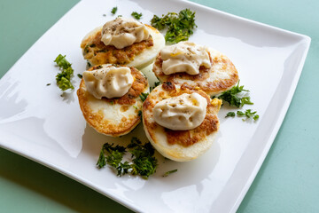 French high cuisine starter dish, pan fried chicken eggs with special filling and yellow sauce, vegetarian food in French restaurant
