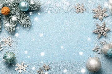 Light blue Christmas frame. Fir tree, New Year ornaments. Winter holiday snowy background, copy space, flat lay.