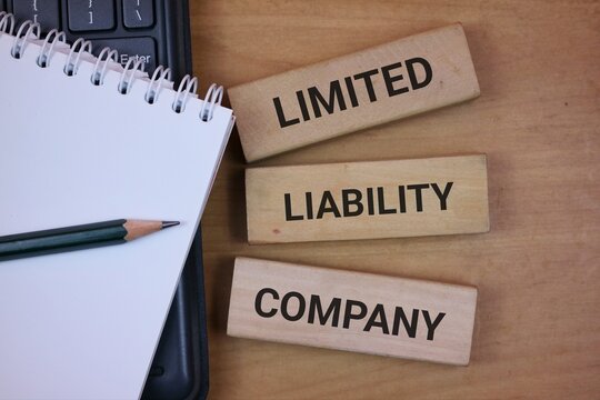 Limited Liability Company Concept Shown On Laptop Keyboard With Notebook And Pencil For Business Documents