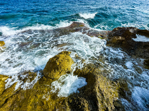 Waves crashing on rocky shore at sunset, capturing the beauty of nature's coastal symphony in vibrant colors and calm soundscapes