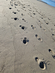 Human footprints in the sand on the coast of Forte de Marmi, Italy. Shot on a phone camera.