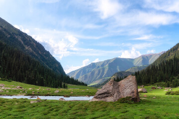 Djeti-Oguz valley landscape with mountains, river and big stone. Tien Shan mountain ridge, located in the southeast of the Issyk-Kul basin, Kyrgyzstan.