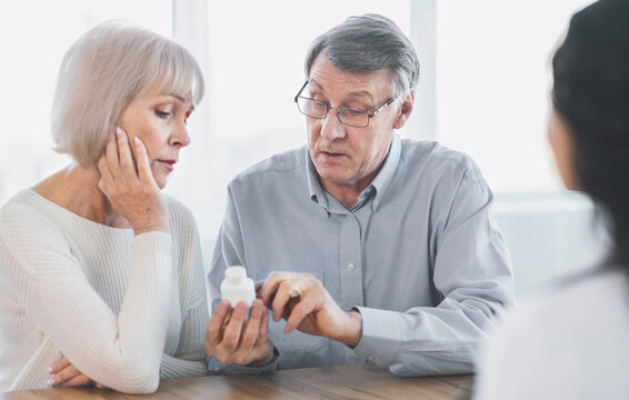 Fototapeta Prescription Medication. Confident senior man pointing at bottle, reading instructions, asking doctor a question