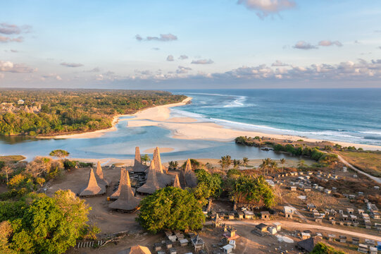 Aerial drone view of the village of Ratenggaro with the traditional houses and beautiful sea coast during sunset at the western site of Sumba island, Indonesia
