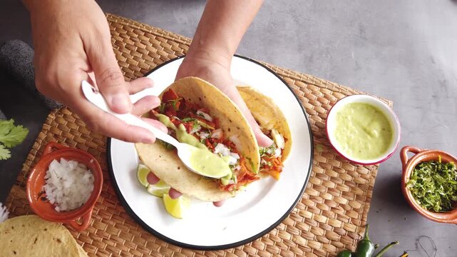 Mexican woman hands preparing tacos al pastor and eating mexican food in Mexico Latin America