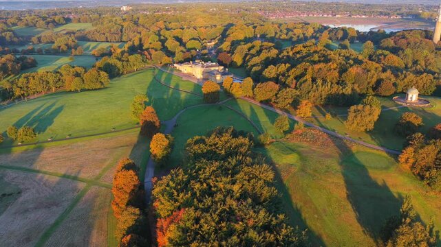 Sunrise aerial video of Heaton Park in Prestwich, Manchester with lush fields, trees, and the temple surrounded by morning light.