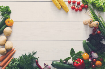 Border of fresh organic vegetables on white wood background. Healthy natural food on table with...