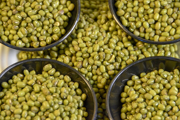 Photograph, Close-up of green gram (Vigna radiata) seeds, commonly called mung beans or ‘Kacang Hijau’, isolated on white background.