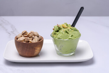 Bowl with pistachio ice cream on a plate.
