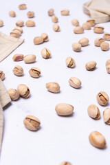 Several pistachio nuts in their shells on a light-colored countertop.