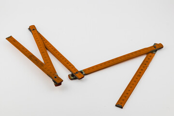 Vintage wooden folding ruler with measurement markings on a white background
