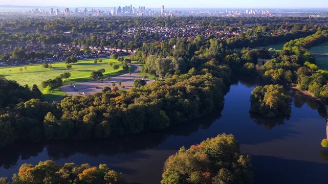 Aerial video of Heaton Park boating lake in Prestwich with Manchester skyline in the distance at sunrise.