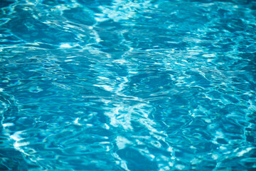 Ripped water in swimming pool. Surface of blue swimming pool, background of water.