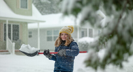 Child clearing sidewalks and shoveling snow. Child removing snow with shovel. Little helper. Winter kids fun outdoor. Child with a shovel is clearing snow after strong snowstorm. Winter cold season. © Volodymyr