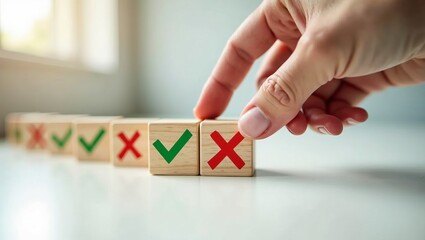 Decision making concept of choosing between right and wrong. Hand selects a wooden cube with a red cross or green check mark.