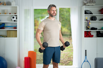 Man Lifting Dumbbells at Home. Fit Latin Man Exercising with Weights. Mature Man with Dumbbells...