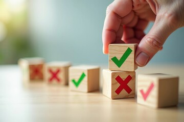 Decision making and evaluation concept with a hand choosing a green check mark block over a red cross for approval.