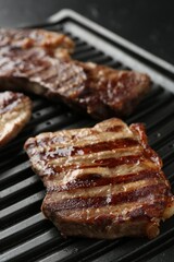 Electric grill with delicious beef meat on table, closeup